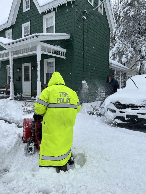 Milton Volunteer Fire Department Fire Police Jesse Millman helps neighbor Milton Fire Chief Gene Dvornick on Chestnut Street in Milton. KEVIN SPENCE PHOTO